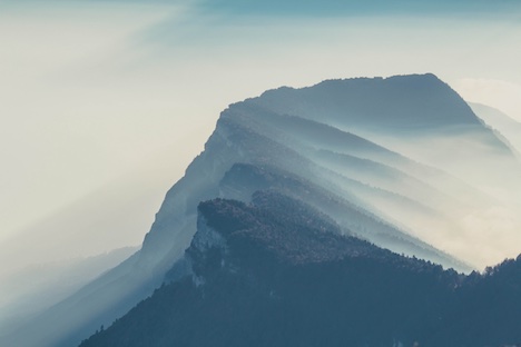 A mountain ridge with mist blowing over it. 